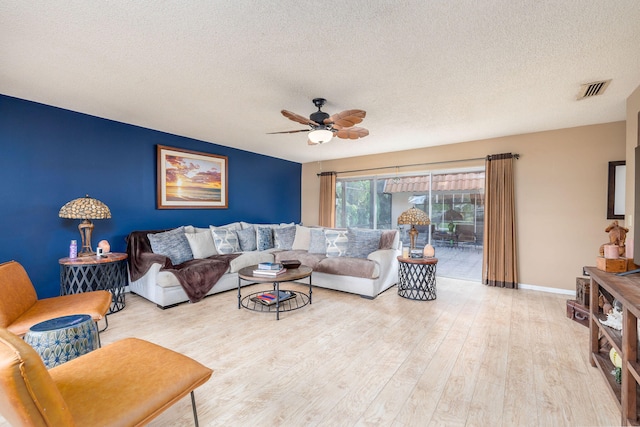 living room featuring ceiling fan, a textured ceiling, and light hardwood / wood-style flooring