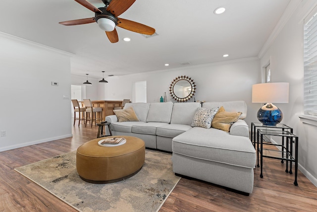 living room with ceiling fan, hardwood / wood-style floors, and ornamental molding