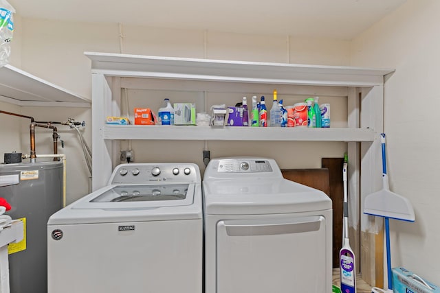 clothes washing area featuring water heater and washer and clothes dryer