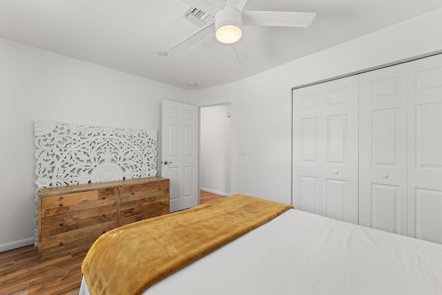 bedroom with dark wood-type flooring, a closet, and ceiling fan