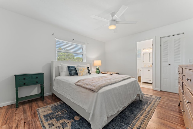 bedroom featuring dark hardwood / wood-style flooring, a closet, ceiling fan, and ensuite bathroom