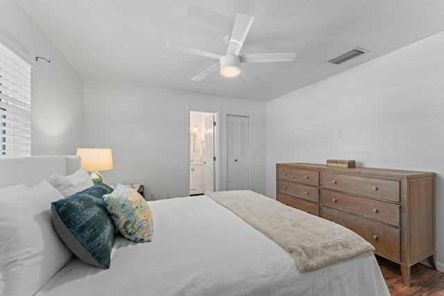 bedroom featuring dark wood-type flooring, ceiling fan, connected bathroom, and a closet