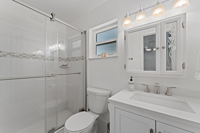 bathroom with walk in shower, vanity, and toilet