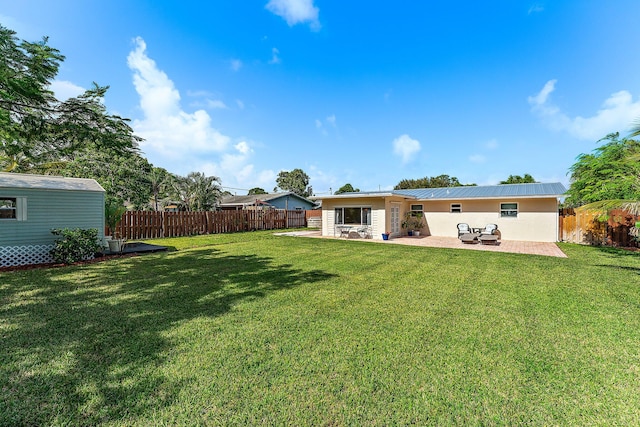 rear view of property featuring a patio and a yard