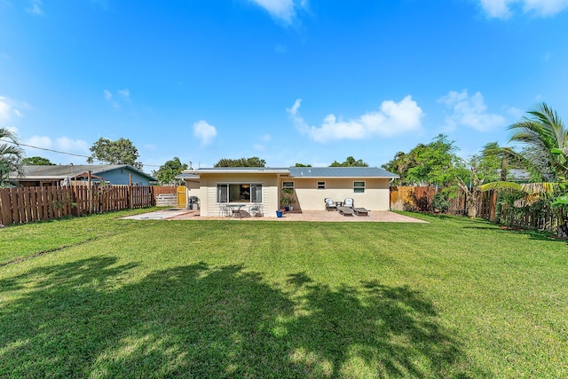 rear view of property featuring a patio and a yard