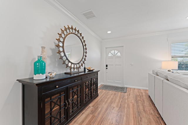 entryway with crown molding and light hardwood / wood-style flooring