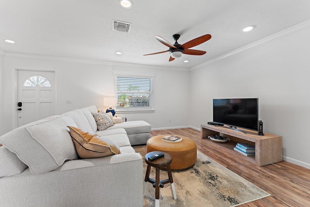 living room featuring ornamental molding, hardwood / wood-style flooring, and ceiling fan