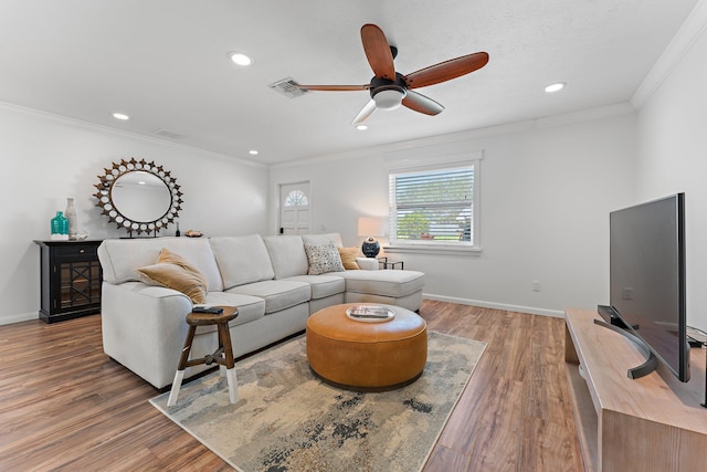 living room with hardwood / wood-style flooring, ceiling fan, and crown molding