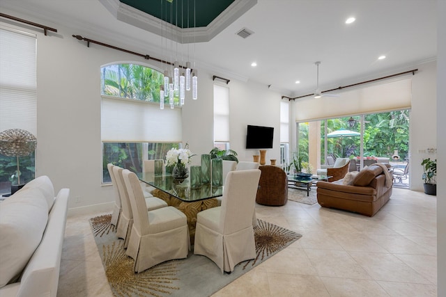 dining space with light tile patterned flooring, crown molding, and a wealth of natural light