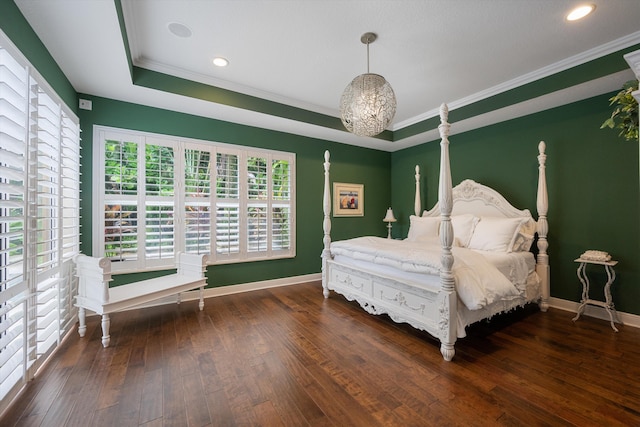 bedroom with ornamental molding, a tray ceiling, and dark hardwood / wood-style flooring