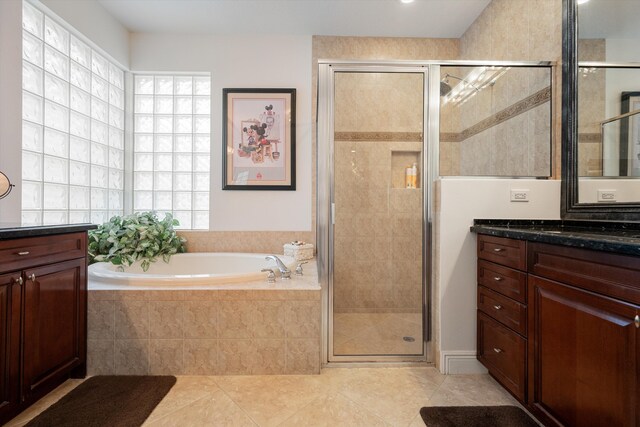 bathroom featuring tile patterned flooring, separate shower and tub, and vanity