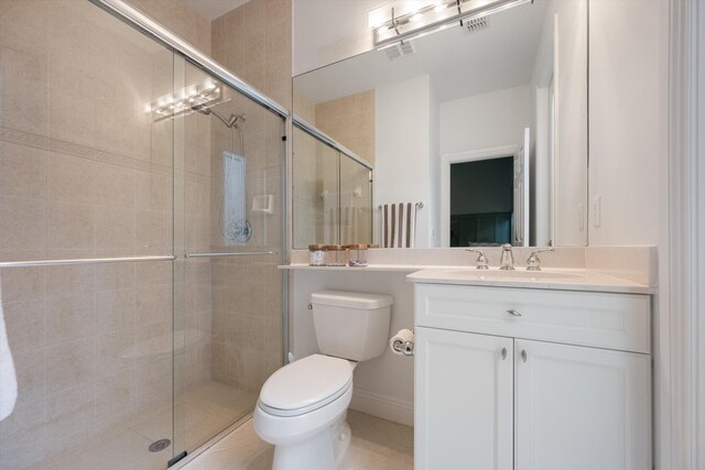 bathroom with tile patterned floors, a shower with shower door, vanity, and toilet