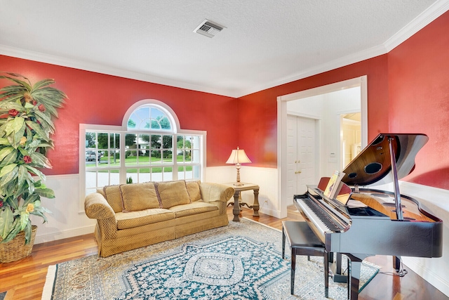 living room featuring a tile fireplace, wood-type flooring, and ornamental molding