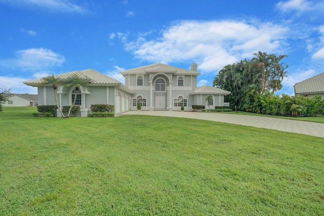 mediterranean / spanish house featuring a front yard and a garage