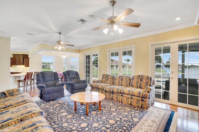 living room featuring ornamental molding, ceiling fan, and french doors