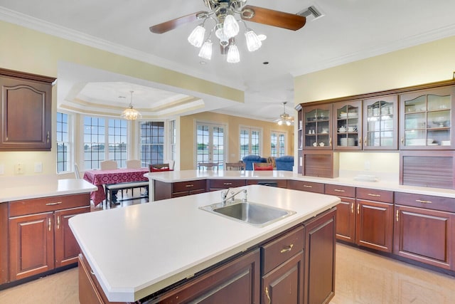 kitchen with a kitchen island with sink, sink, kitchen peninsula, a raised ceiling, and ceiling fan