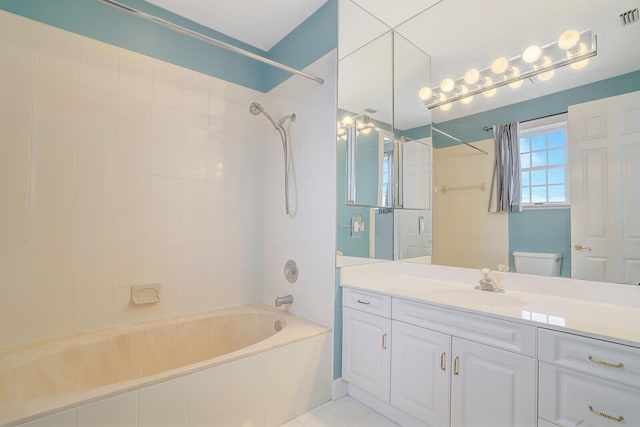 full bathroom with vanity, tiled shower / bath combo, toilet, and tile patterned floors