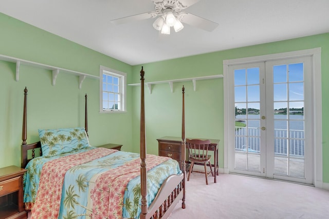 bedroom featuring french doors, a water view, ceiling fan, and access to outside