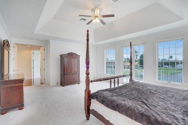 carpeted bedroom with access to outside, a tray ceiling, and ceiling fan