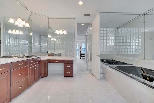 bathroom featuring tiled tub and vanity