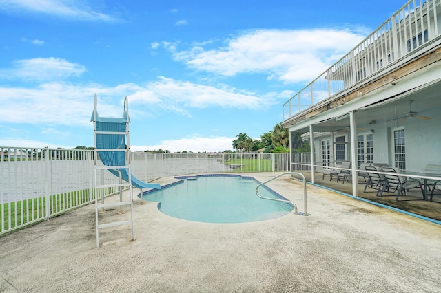 view of swimming pool featuring a patio, ceiling fan, and a water slide