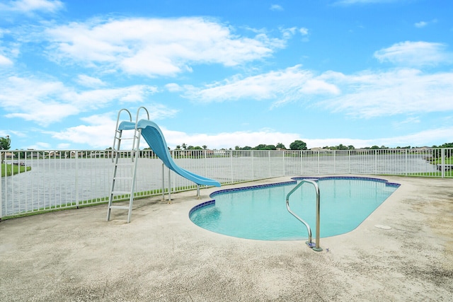 view of swimming pool featuring a patio and a water slide