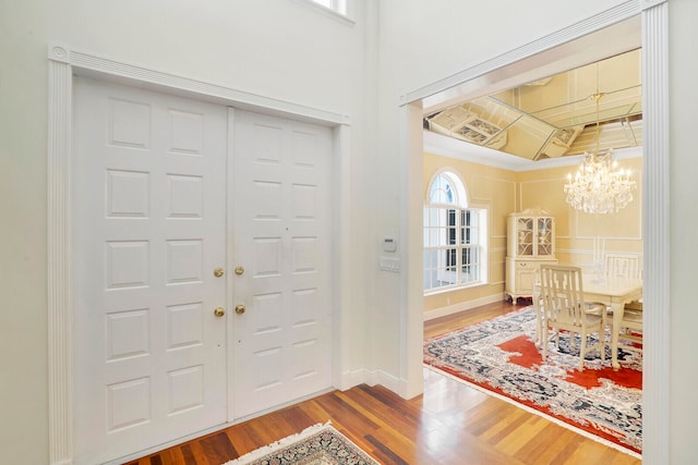 entryway with light wood-type flooring, crown molding, and a wealth of natural light