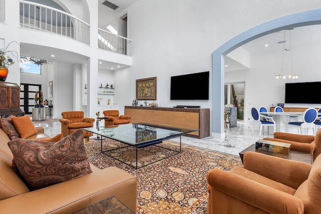 living room with a notable chandelier and a towering ceiling