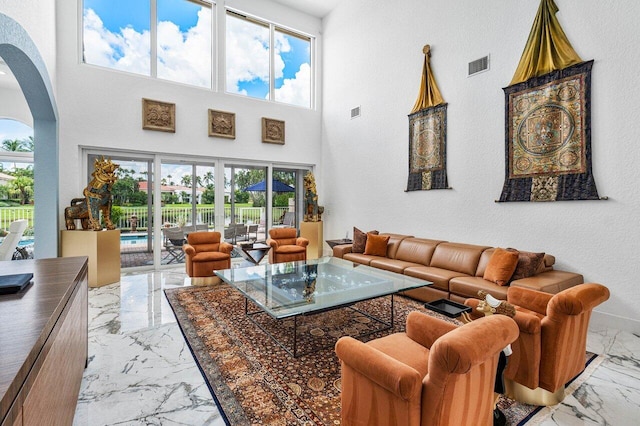 living room with a towering ceiling and a healthy amount of sunlight