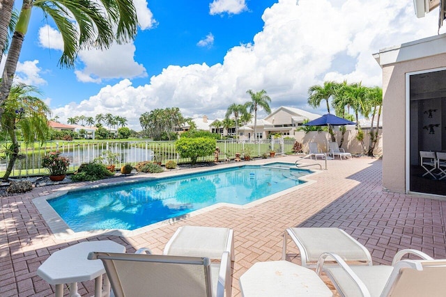 view of pool featuring a patio area and a water view