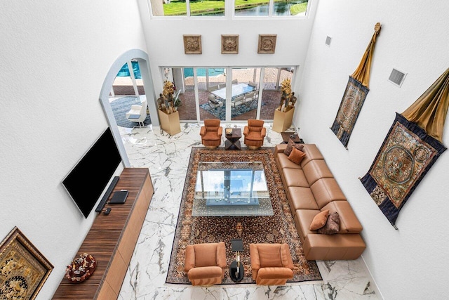 living room with a high ceiling and plenty of natural light