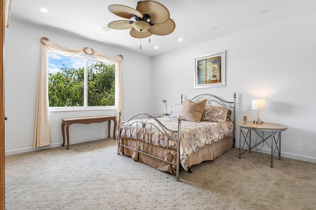 carpeted bedroom featuring a textured ceiling and ceiling fan