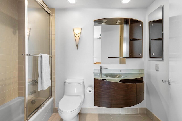 full bathroom with tile patterned flooring, shower / bath combination with glass door, toilet, and vanity