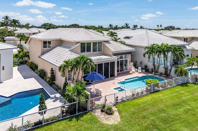 rear view of property with a lawn, a fenced in pool, and a patio area