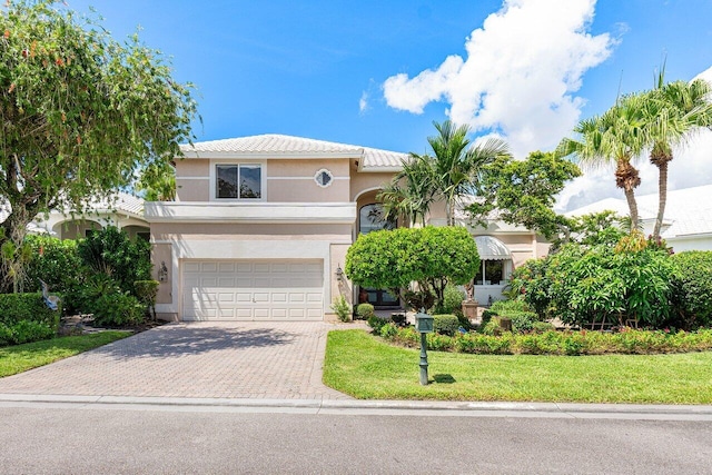 mediterranean / spanish house featuring a garage and a front yard