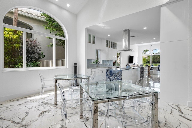 dining space with a chandelier, sink, and lofted ceiling