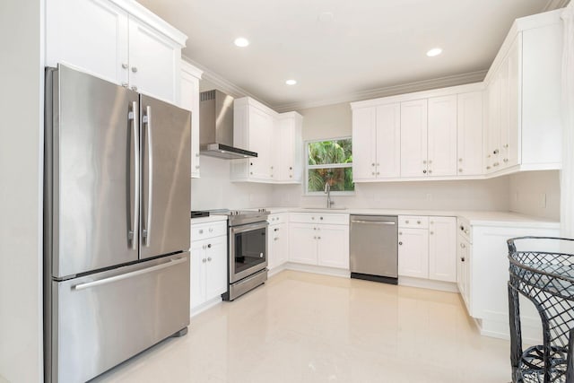 kitchen with sink, white cabinetry, stainless steel appliances, ornamental molding, and wall chimney exhaust hood