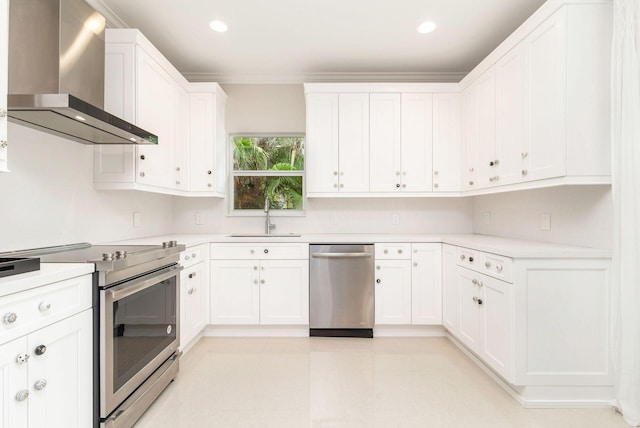 kitchen featuring wall chimney exhaust hood, sink, white cabinetry, crown molding, and stainless steel appliances