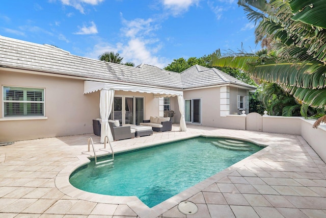 rear view of house with an outdoor living space and a patio area