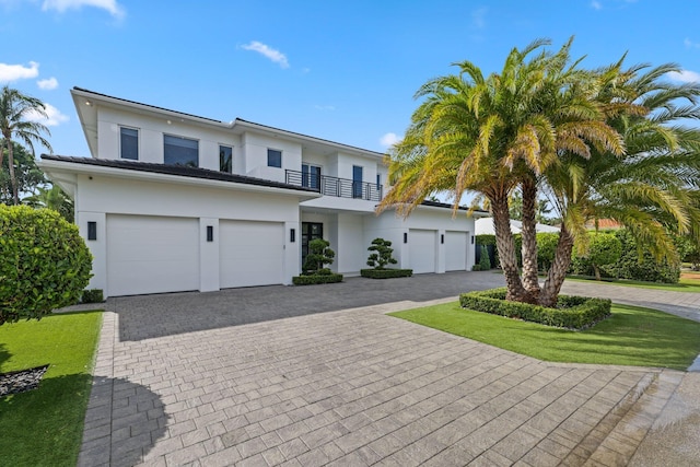 view of front of property with a front lawn, a balcony, and a garage