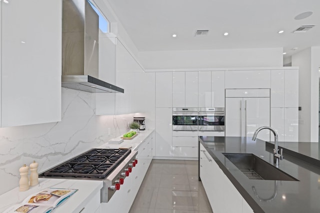 kitchen featuring white cabinets, sink, and wall chimney range hood