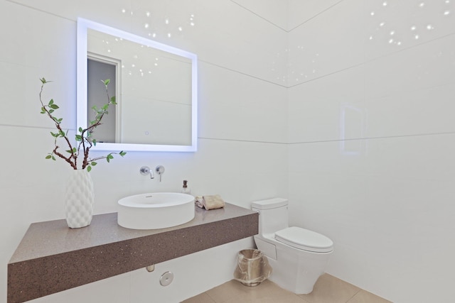 bathroom featuring tile patterned flooring, tile walls, vanity, and toilet