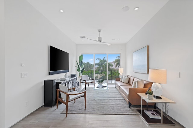 living room featuring ceiling fan and light hardwood / wood-style flooring