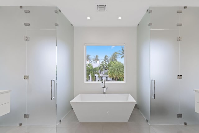 bathroom featuring tile patterned flooring, plus walk in shower, and vanity