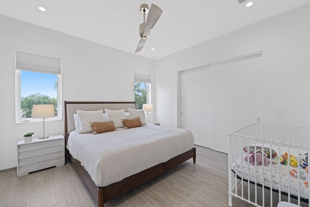 bedroom with hardwood / wood-style flooring, multiple windows, and ceiling fan