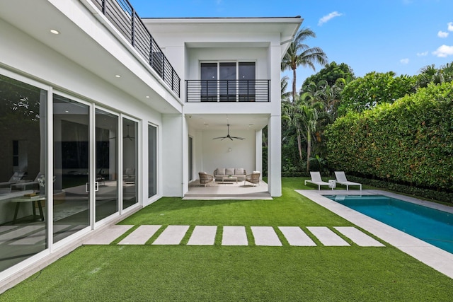 back of property with outdoor lounge area, a yard, ceiling fan, a balcony, and a patio area