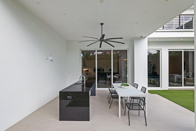 view of patio featuring ceiling fan and sink