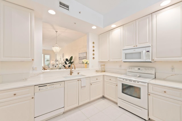 kitchen featuring white appliances, sink, hanging light fixtures, light tile patterned flooring, and a chandelier