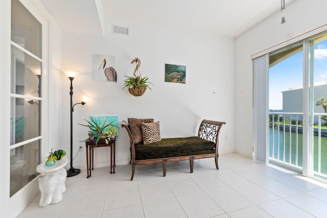 living area featuring a water view and light tile patterned floors