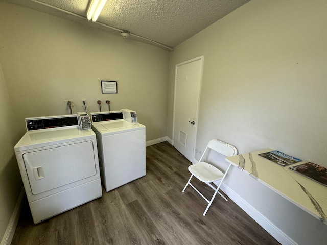 washroom featuring a textured ceiling, washing machine and dryer, and dark wood-type flooring